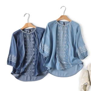 Detail of embroidered bohemian patterns on denim shirts with 3/4 puff sleeves