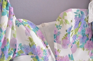 Close-up of floral print fabric featuring hidden zipper and purple blossom details