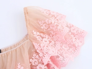 Detail shot of light pink mesh layering with delicate floral embroidery on the sleeve