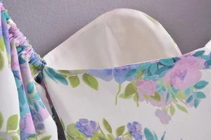Close-up of floral chiffon dress detailing purple flower prints and elastic pleats