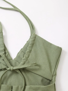 Détail de la robe vert sauge avec rubans à lacets et fermeture éclair discrète au dos