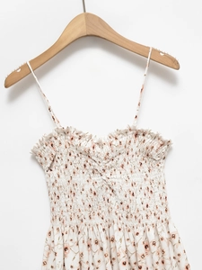 Detail of floral backless dress showing smocked chest design and ruffled neckline