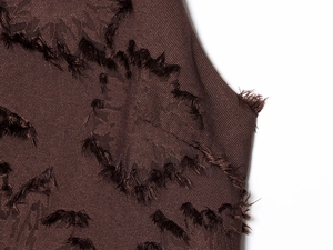Gros plan sur le tissu marron foncé avec détails floraux en relief sur la robe d'été