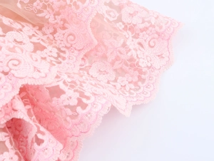Close-up of pink layered mesh top with detailed floral embroidery and scalloped lace edges