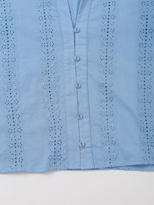 Detail of light blue embroidered eyelet shirt with small matching buttons and fine stitching