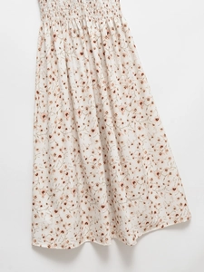 Detail view of the floral print fabric and smocked elastic waistband of the dress