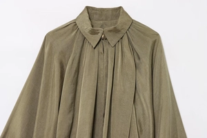 Detail of olive green bomber jacket collar with metallic zipper and pleated suede fabric