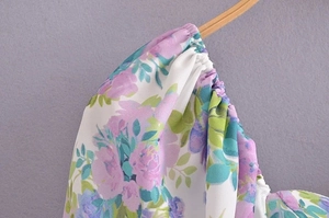 Detailed macro of floral summer dress shoulder with elastic smocking and purple flowers