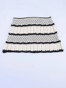 Sleeveless knitted striped mini dress in cream and black with intricate hollow patterns