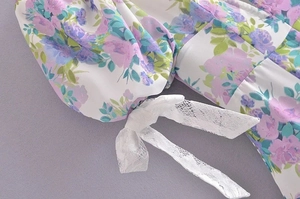 Detailed close-up of floral puff sleeve with delicate white lace bow and sweet patterns