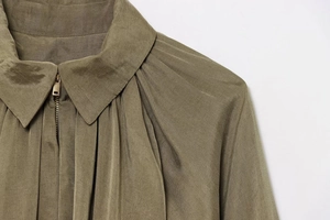 Detail of army green bomber jacket with lapel collar and gathered pleated texture