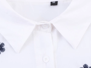 Gros plan d'une chemise en popeline blanche avec broderie de palmier et détail du col M