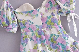 Back detail of floral dress showing puff sleeves, lace ties, and invisible zipper closure