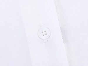 Vue macro d'un tissu de chemise en popeline blanche avec un détail soigné de bouton à quatre trous