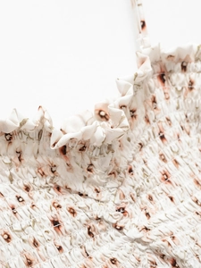 Close-up of floral print smocked dress featuring ruffle trim and thin spaghetti straps