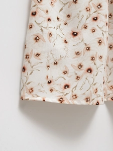 Detailed macro view of the floral print fabric and clean hem stitching on the dress