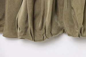 Detail of olive green bomber jacket featuring gathered elastic cuff and premium textured fabric