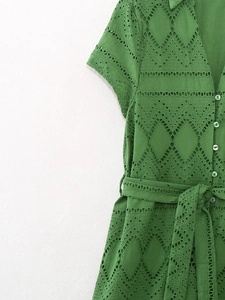 Detail of green eyelet embroidery fabric with buttons and tie waist on the summer dress