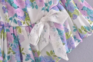 Macro detail of French vintage floral fabric with a delicate white lace bow accent