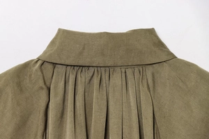 Detail of olive green bomber jacket featuring a structured collar and pleated fabric texture