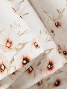 Detail of floral woven fabric with neat stitching and brown floral print on beige