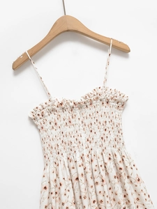 Detail of floral backless dress showing smocked chest with ruffled edges and thin straps