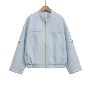 Detail of light blue tweed jacket showing baseball collar and metal zipper closure
