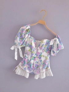 French vintage floral romper with puff sleeves and lace bows on a white background