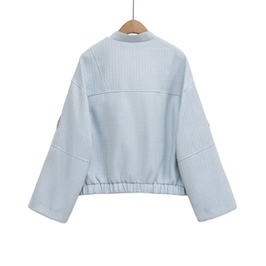 Back view of light blue tweed jacket with drop shoulders and elastic hem detailing