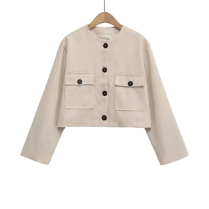 Detailed view of beige tweed jacket with large flap pockets and contrast black buttons