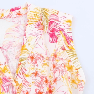 Détail de l'imprimé floral tropical sur chemise blanche sans manches à col en V