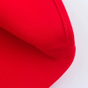 Dettaglio macro del tessuto rosso dell'abito midi con cuciture di qualità e trama a tinta
