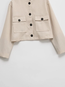 Short beige round neck jacket with large front pockets and black buttons in tweed style