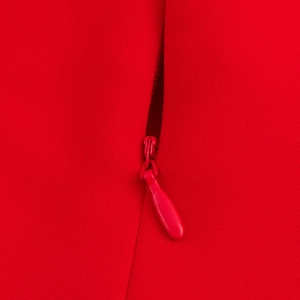 Dettaglio della cerniera invisibile rossa e tessuto in saia su vestito midi smanicato