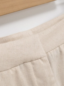 Détail de la taille du pantalon en lin beige avec passants et plis de tissu délicats