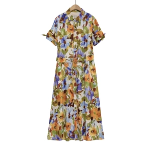 Detail of floral print dress featuring lapel collar, buttons and matching metal buckle belt