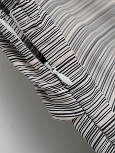 Détail d'une robe dos nu rayée montrant la fermeture éclair blanche invisible