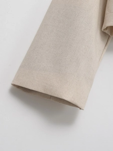 Macro shot of oatmeal tweed jacket cuff showing detailed texture and stitching
