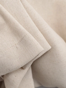 Macro view of textured tweed fabric with neat stitching on this cream short jacket