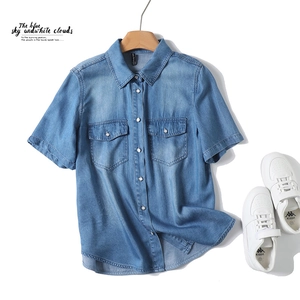 Detail of light blue tencel denim shirt showing wash effect and double pockets