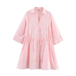 Detailed view of pink mini dress featuring hollow embroidery and adjustable waist drawstring