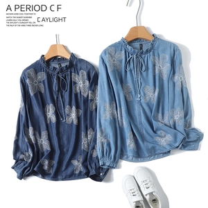 Détail de broderie florale sur chemise en denim à manches longues et col volanté