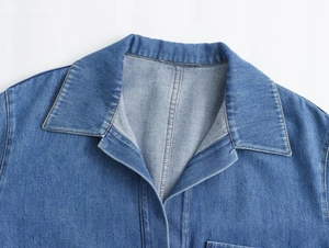 Primer plano detallado del cuello de solapa y costuras en una chaqueta vaquera