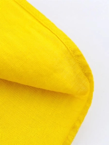 Bright yellow summer dress showing fine plain weave texture and high-quality hem stitching