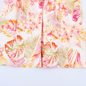 Détail de l'imprimé floral tropical et de l'ourlet plissé sur tissu de robe d'été