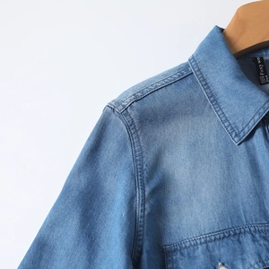 Detail of classic collar and shoulder stitching on a light blue tencel denim shirt