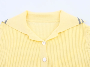 Detail of yellow ribbed knit cardigan collar with contrast grey stripes and white buttons