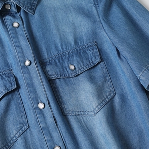 Detailed view of tencel denim shirt featuring pearl snap buttons and chest flap pockets