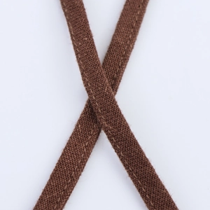 Détail de la sangle plate tissée marron café avec une texture croisée haut de gamme