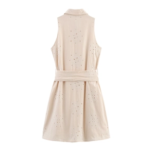 Close-up of beige eyelet embroidery and matching waist belt on a sleeveless mini dress